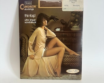 Puede incluir: Medias vintage Sears Clingalon thi-top ultra transparentes con sandalia en un paquete marrón. El paquete presenta a una mujer con una bata beige y medias. El texto "Sears" y "all nylon" también está incluido.