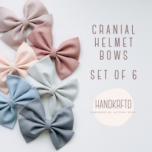 May include: Set of six fabric bows in shades of pink, blue, and gray. The bows are arranged in a semi-circle on a white background. The text "Cranial Helmet Bows Set of 6" is displayed above the bows. The text "HANDKRFETD Handmade by Katrina Rose" is displayed below the bows.