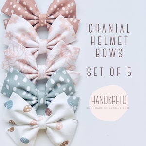 May include: Set of five handmade fabric bows in various patterns, including floral, polka dots, and geometric designs. The bows are designed for cranial helmets and are labeled "Cranial Helmet Bows Set of 5" and "Handkrfted Handmade by Katrina Rose".