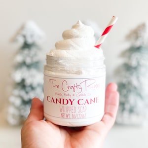 May include: A white whipped soap in a clear jar with a red and white striped straw. The jar has a white label with the text "The Crafty Roses Bath, Body & Candle Co. CANDY CANE WHIPPED SOAP NET WT. 8oz (226g)"