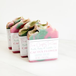 May include: Three bars of handmade soap with a pink and green swirl design. The soap is labeled "The Crafty Roses Bath, Body & Candle Co. Cactus Flower Handmade Soap Bar Net Wt. 4.5 oz (128g)"