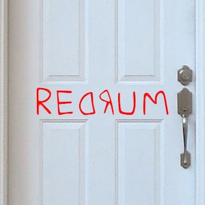 Puede incluir: Una puerta blanca con una manija de puerta plateada y un pomo de puerta plateado. La palabra "REDЯUM" está escrita en rojo en la puerta.