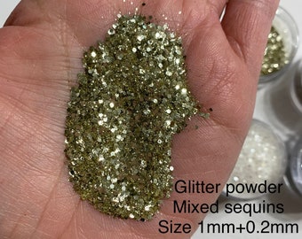 May include: A close-up of a hand holding a pile of gold glitter powder and sequins. The text on the image reads "Glitter powder Mixed sequins Size 1mm+0.2mm".