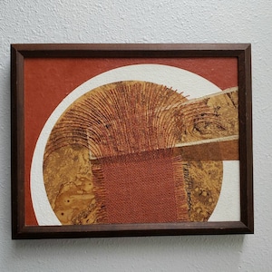 May include: A framed abstract art piece with a brown, white, and gold color scheme. The artwork features a woven texture and a signature in the bottom right corner that reads "Hamil Thompson".