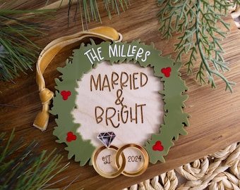 May include: A green wreath ornament with the text "The Millers Married & Bright" and two gold rings with the dates "Est. 2021" and "2024".