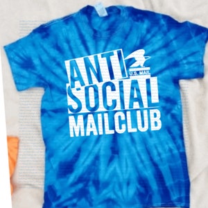 May include: A blue tie-dye t-shirt with white text that reads "Anti Social Mail Club" with a U.S. Mail logo above the word "Social".