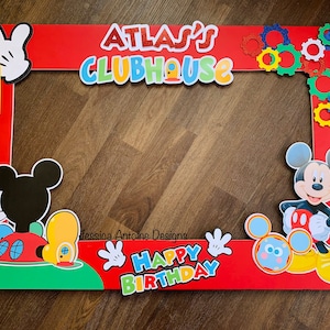 May include: Red photo booth prop with Mickey Mouse theme. Features the text "Atlas's Clubhouse" and "Happy Birthday". Includes Mickey Mouse and his house, a number 1, and decorative gears.