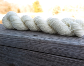 Peut inclure: Un écheveau de fil blanc cassé torsadé en une longue bobine continue. Le fil présente une texture douce et fibreuse avec une couleur crème claire et uniforme sur toute la longueur du faisceau torsadé, présenté comme une unité unique.