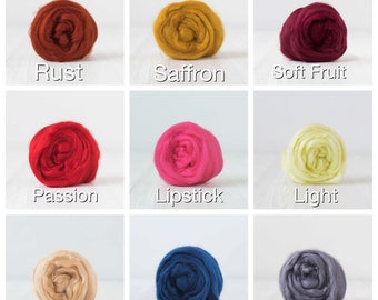 May include: A grid of nine balls of wool roving in various colors labeled Rust, Saffron, Soft Fruit, Passion, Lipstick, Light, Dune, Evening, and Fog. Each ball is a circular, textured mass of fiber arranged in a consistent, organized display.
