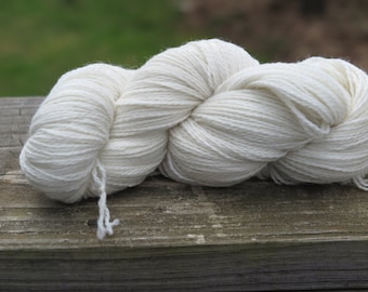 Peut inclure: Un écheveau de fil torsadé épais de couleur blanc cassé. Le fil présente une construction à plusieurs brins avec une texture mate et douce, ainsi qu'une couleur crème naturelle et uniforme sur toute la longueur de la fibre, présenté en écheveau.