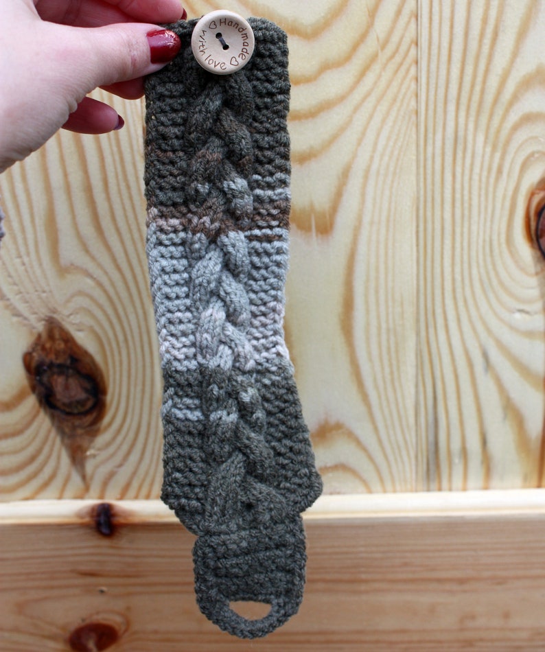 May include: A green, white, and brown knitted bracelet with a wooden button that says "Handmade with Love".