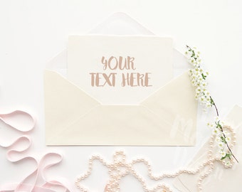 Download Envelope With Blooming Branch String Of Beads And A Pink Ribbon On A White Desktop 2 Stock Photography Product Mockup High Res File Mockups Templates Psd Free Download PSD Mockup Templates