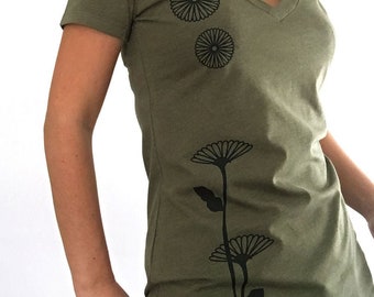 May include: A green t-shirt with a black floral design. The design features three stylized flowers with a stem and leaves.