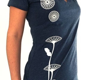 May include: A navy blue t-shirt with a white floral design. The design features three stylized flowers with stems and leaves.