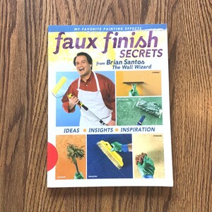 May include: A book titled "faux finish SECRETS" by Brian Santos, The Wall Wizard. The book cover features a man in a white apron holding a paint roller and a close-up of different painting techniques.