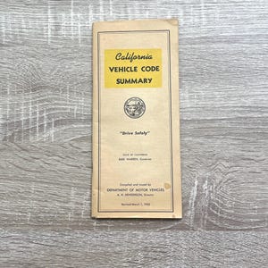 May include: A vintage California Vehicle Code Summary booklet. The cover features a yellow rectangle with the title in black text. The booklet includes the text "Drive Safely" and the date "Revised March 1, 1952".