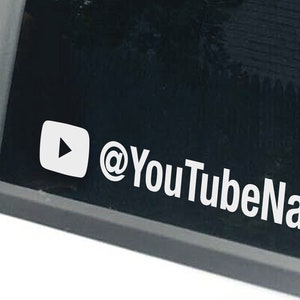 Peut inclure: Autocollant en vinyle blanc avec un bouton de lecture et le texte "@YouTubeNameHere" pour une vitre de voiture.
