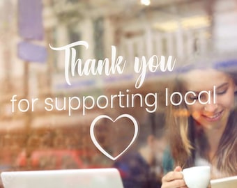 May include: A white sign on a glass door with the text "Thank you for supporting local" and a heart symbol.