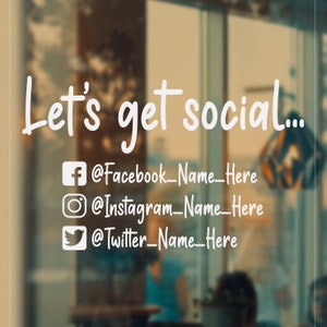 May include: A white sign on a glass door with the text "Let's get social..." and social media icons with handles for Facebook, Instagram, and Twitter.