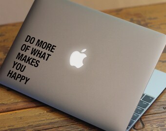 May include: A silver laptop with a black sticker that says "Do more of what makes you happy". The laptop has a white Apple logo.
