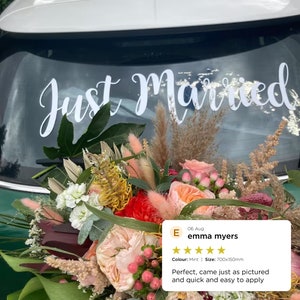May include: A white "Just Married" car decal on a green car with a bouquet of flowers in front of it. The decal is 700mm by 150mm and is mint green in color. The review says "Perfect, came just as pictured and quick and easy to apply."