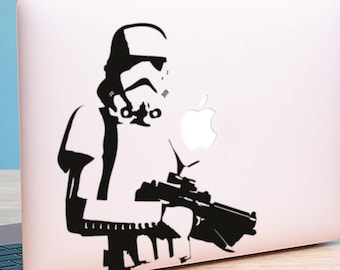 May include: A black and white silhouette of a Star Wars Stormtrooper holding a blaster rifle on a silver laptop.