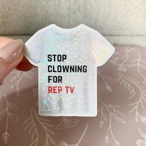 May include: A white t-shirt sticker with a holographic finish. The sticker has the text "STOP CLOWNING FOR REP TV" printed in black.