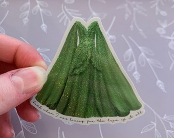 May include: A green glitter dress with a long train and a quote that reads "back when I was living for the hope of it all".