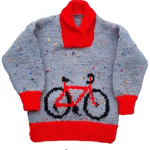 Pode incluir: Um suéter de tricô cinza e vermelho com um design de bicicleta. O suéter é feito com tricô duplo e tem uma gola vermelha. O suéter é para um peito de 20-26 polegadas.