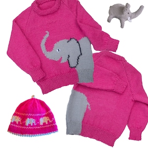 Puede incluir: Un conjunto de punto rosa de suéter y gorro con diseño de elefante. El suéter tiene un elefante gris en la parte delantera y el gorro tiene una fila de pequeños elefantes grises. El suéter es para un pecho de 61 a 76 cm.