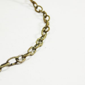 May include: A close-up of a gold chain made of oval links.