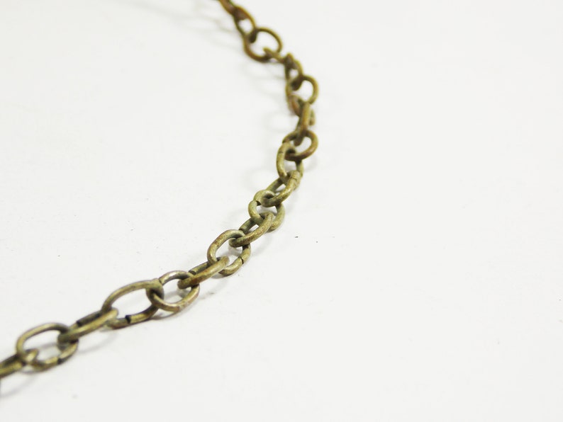 May include: A close-up of a gold chain made of oval links.