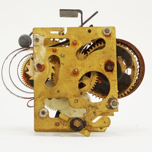 May include: Close-up of a vintage clock mechanism with brass gears and a spring. The mechanism is rusty and shows signs of wear and tear.