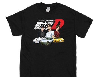 May include: Black t-shirt featuring a graphic of three characters from the anime Initial D. The characters are standing in front of three cars. The text "Initial D" is in red and white. The text "頭文字D" is in Japanese.