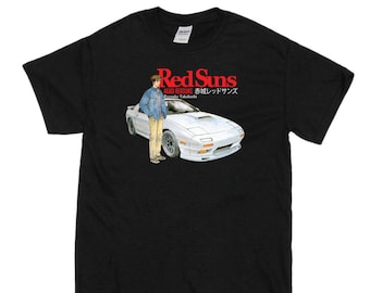May include: Black t-shirt with a graphic of a white sports car and a person in a denim jacket. The text "Red Suns" is in red, with Japanese text below. The shirt is a Gildan brand.