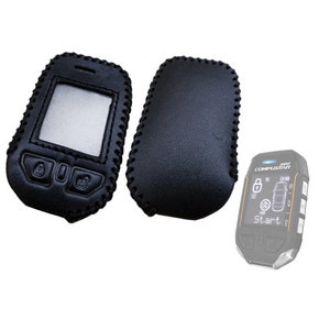 May include: Two black leather key fob covers, one with a stitched edge and the other with a smooth edge. A black and gray car key fob with a digital display and the text "COMFORT START" is also shown.