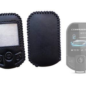 May include: Two black leather key fobs with stitching around the edges. One fob has a clear window and buttons. The other fob is solid black. A third fob is a silver remote with a black screen displaying a car, a lock icon, and the text "COMPUSTAR" and "12.5V 78°F".