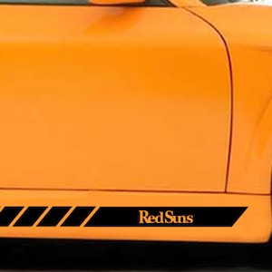 May include: Orange car with a black racing stripe and the words "RedSuns" on the side.