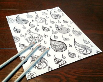 Peut inclure: Une feuille de papier blanche ornée d'un motif cachemire noir et trois crayons gris à pointes bleues. Les motifs cachemire, de tailles et formes variées, présentent des motifs internes complexes.