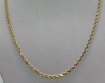 May include: A gold rope chain necklace on a white mannequin bust.