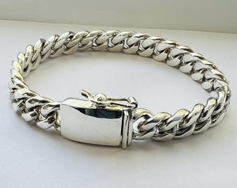 May include: A silver curb chain bracelet with a polished finish and a secure clasp.
