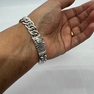 Op de afbeelding: Een zilveren kettingarmband met een sluiting waarop "925" is gegraveerd.