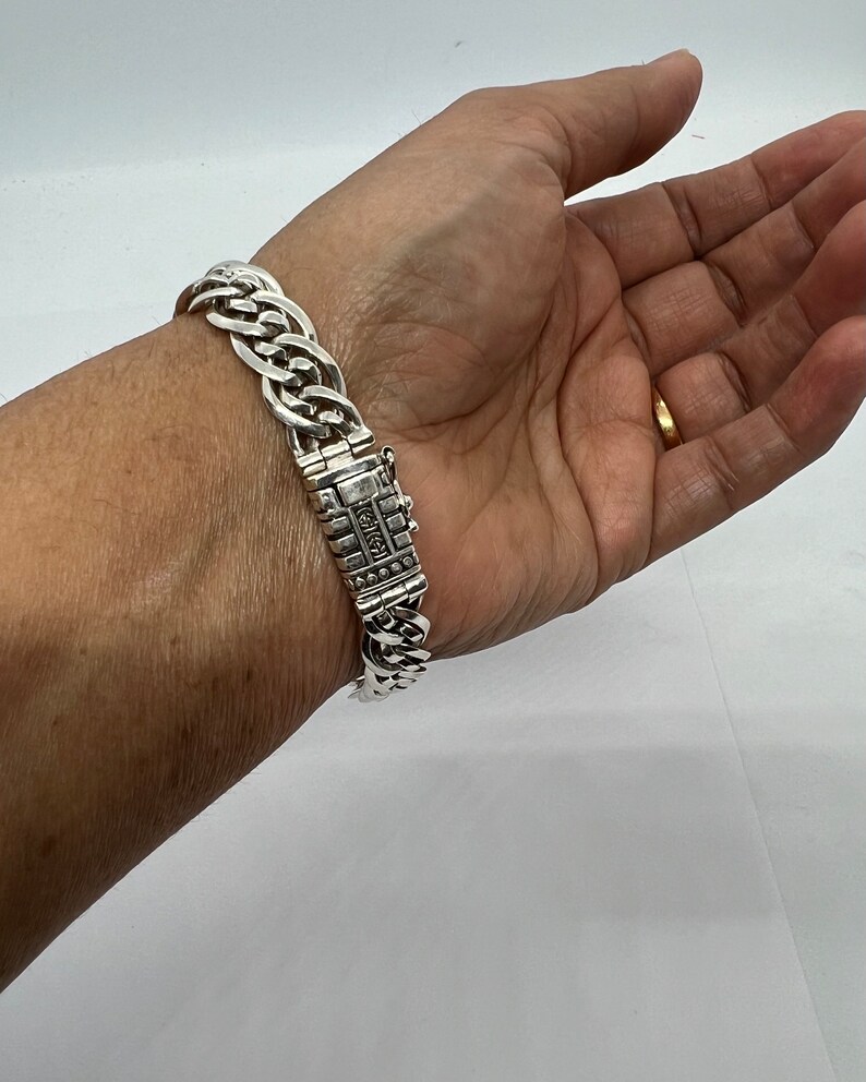 Op de afbeelding: Een zilveren kettingarmband met een sluiting waarop "925" is gegraveerd.