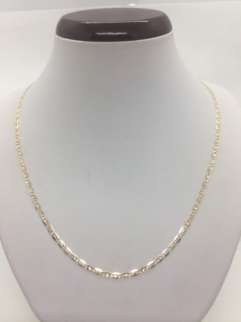 May include: A gold chain necklace with a delicate, textured design. The chain is made of 10k gold and has a lobster clasp closure.