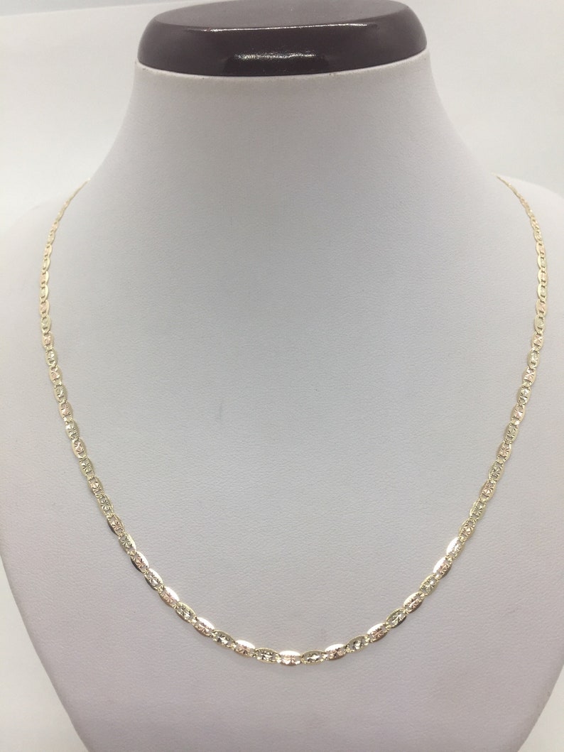 May include: A gold chain necklace with a delicate, textured design. The chain is made of 10k gold and is 18 inches long.
