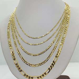 May include: A set of six gold chain necklaces of varying widths, displayed on a white mannequin bust.