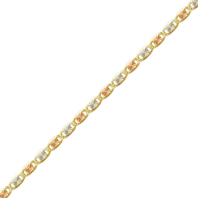 May include: A gold chain with alternating oval links. Each link features a starburst design in gold, rose gold, and silver tones. The chain is displayed against a white background.