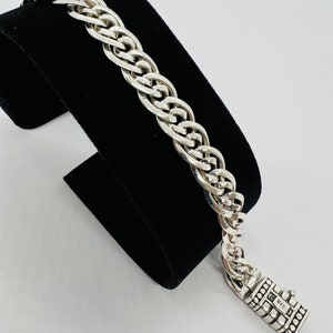Op de afbeelding: Een zilveren armband met een gevlochten ketting en een zilveren sluiting. De sluiting heeft een kleine inscriptie "925".