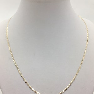 May include: A gold chain necklace with a delicate, flat, oval-shaped link design.