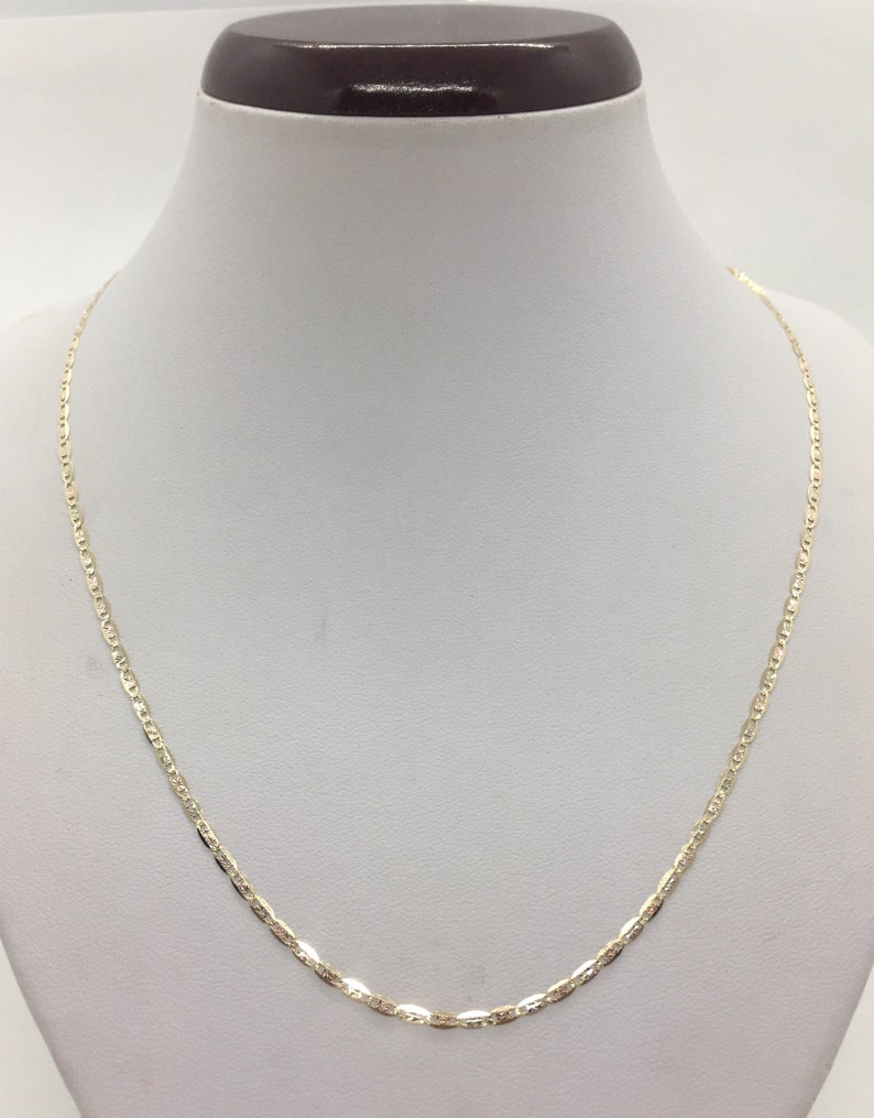 May include: A gold chain necklace with a delicate, flat, oval-shaped link design.